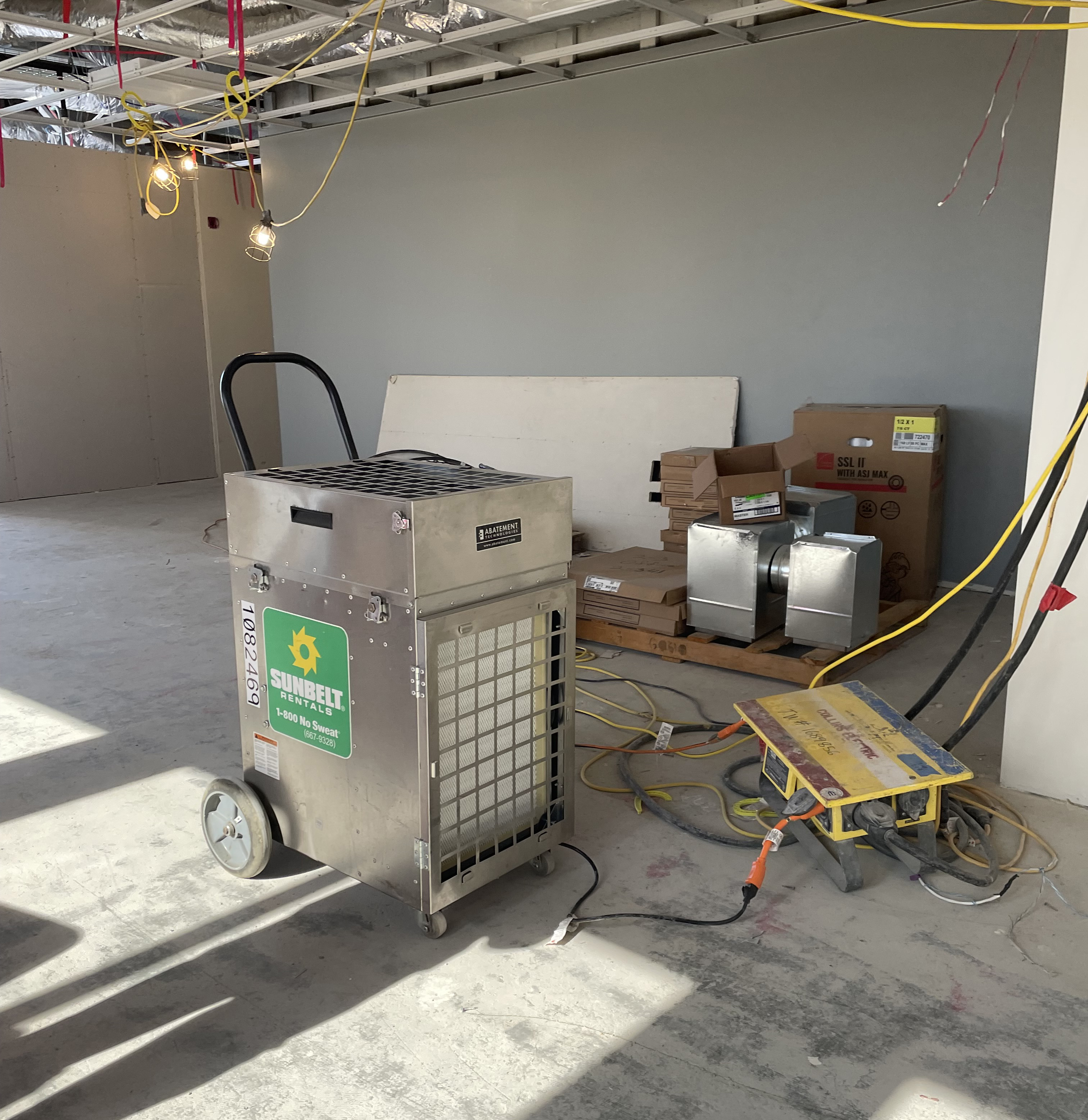 An air scrubber inside of a room under construction.
