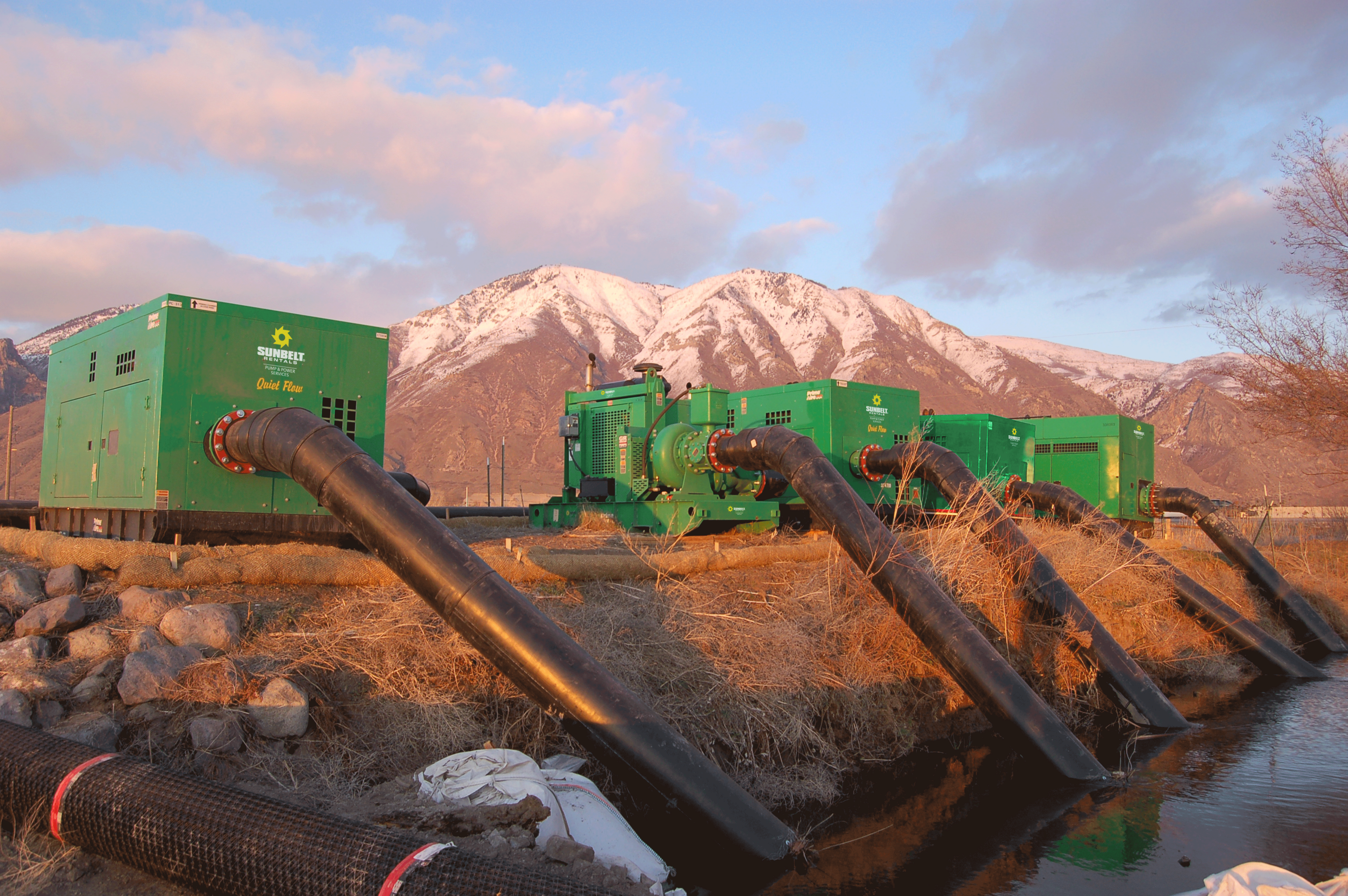 Sunbelt Rentals Quiet Flow water pumps leading into a water source.