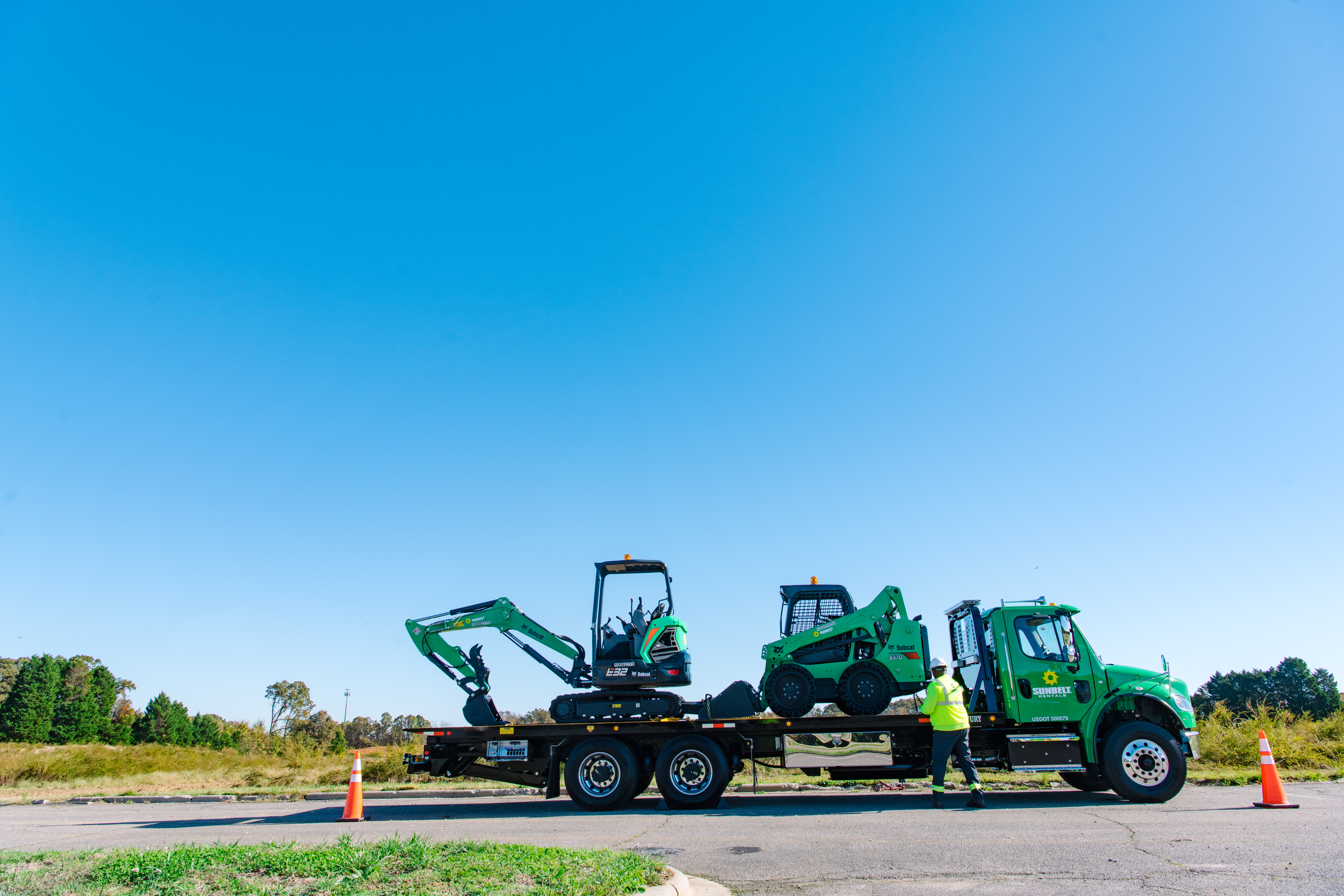 Earth moving equipment from Sunbelt Rentals on a trailer.