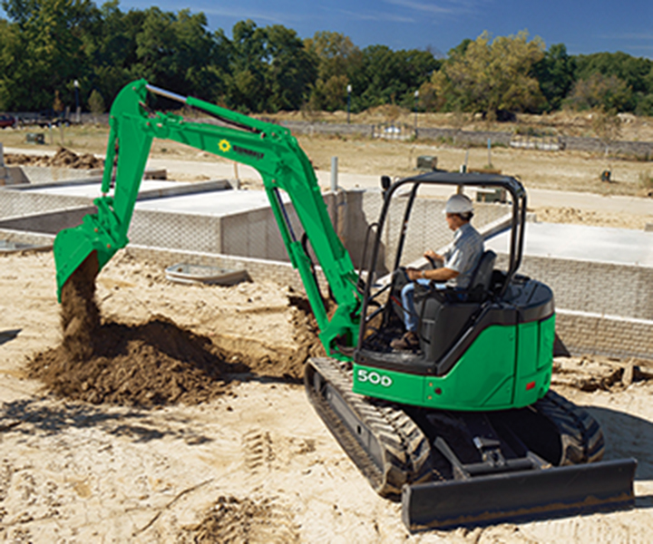 An excavator from Sunbelt Rentals moving dirt at a job site.