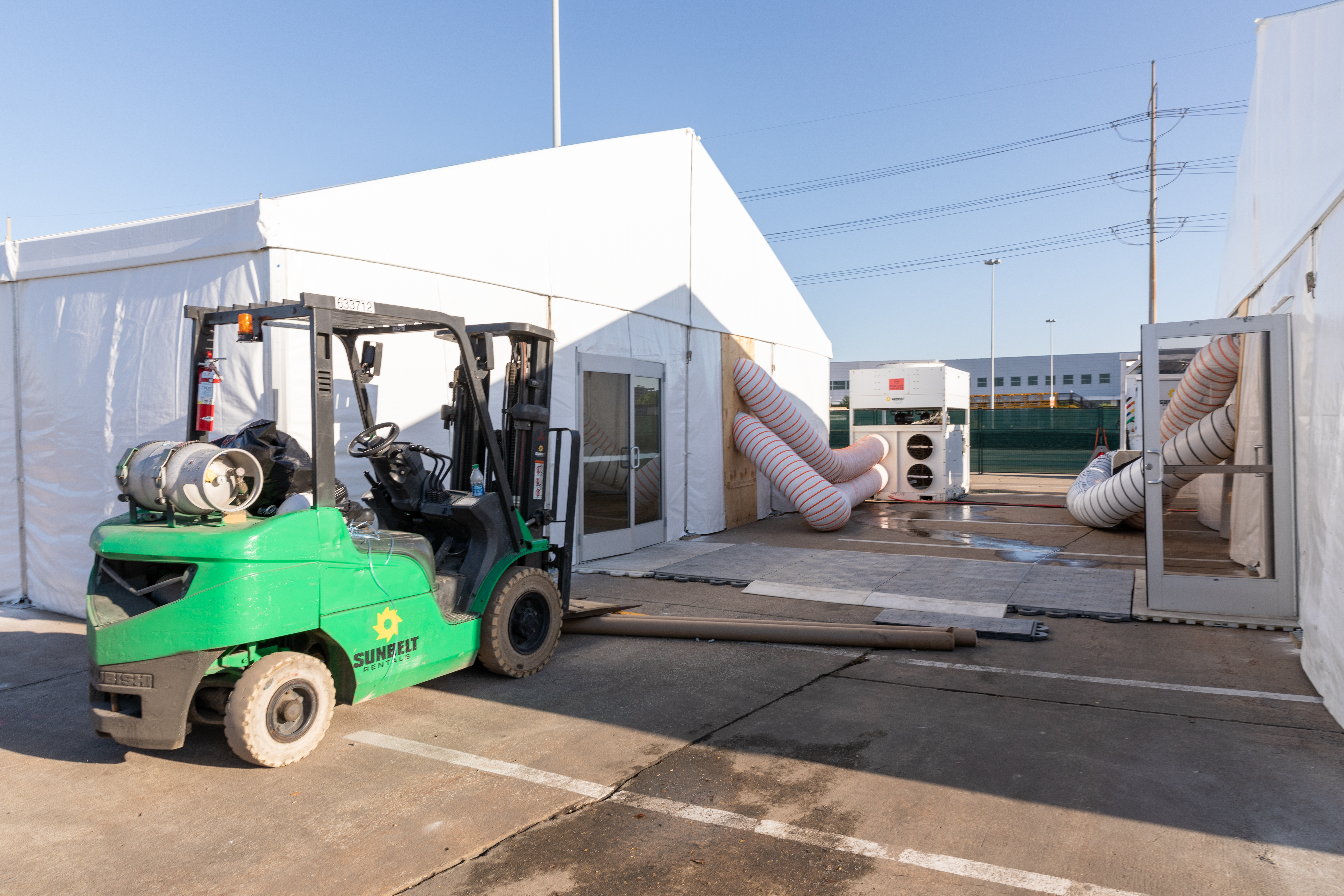 Insulated fabric temporary structures installed at a job site, alongside a forklift.