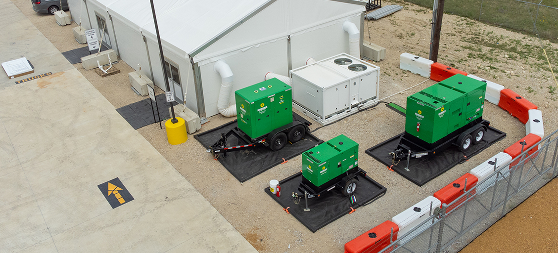 Aerial view of three Sunbelt Rentals energy storage systems outside of a construction site.