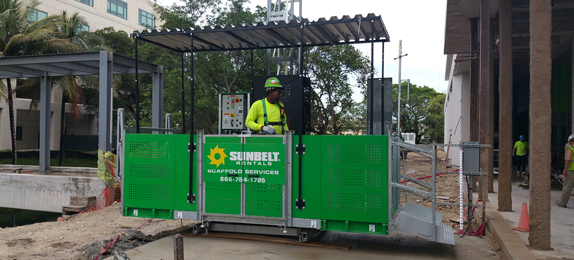 Sunbelt Rentals scaffold services worker on ground level.