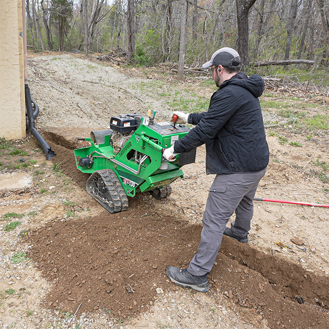 Person using a walk-behind trencher from Sunbelt Rentals.