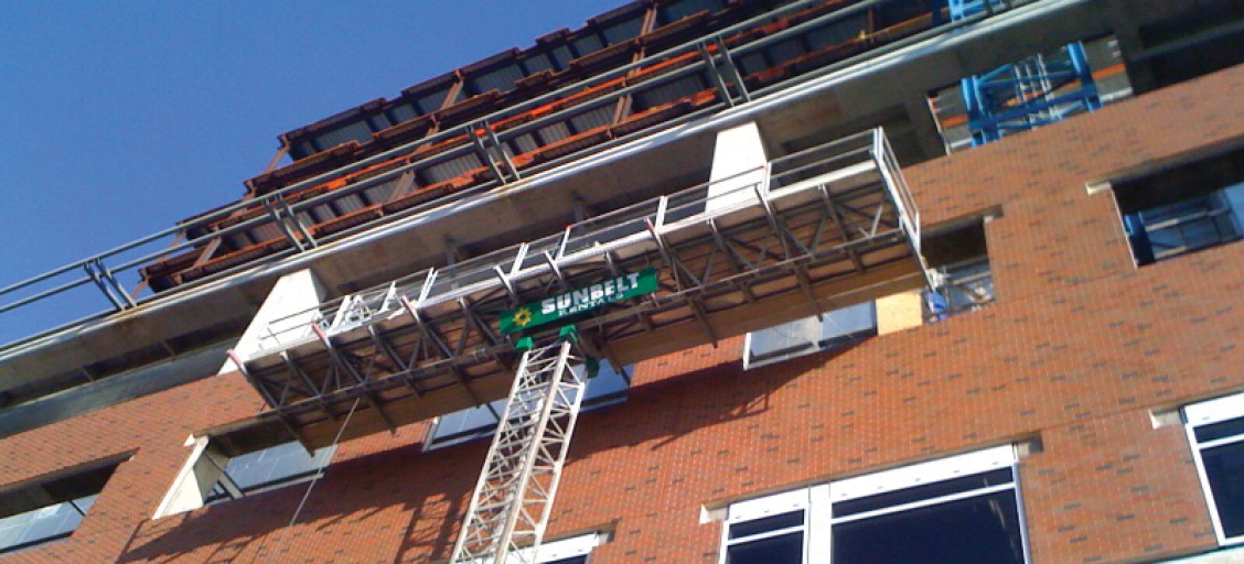 Mast climber system on a brick building.